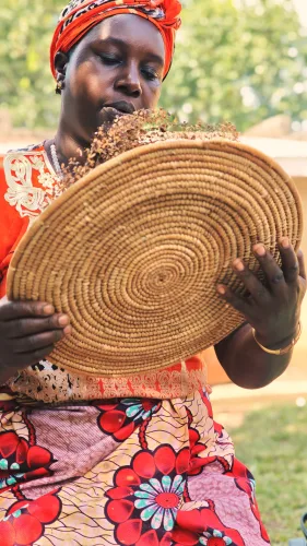 A lady preparing handmade coffee for guests during a community visit