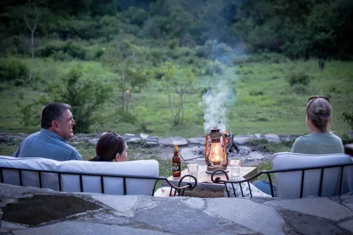 Tourists at a fireplace at Semliki Safari Lodge